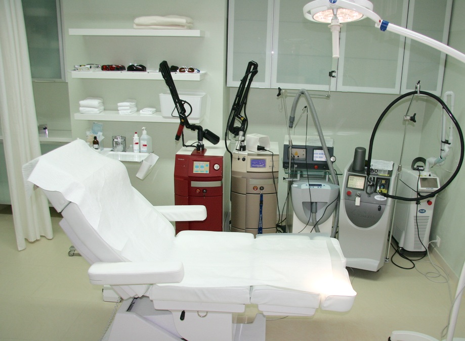 Aufnahme vom Arbeitsplatz eines Tattooentferners: Arbeitsstuhl und Laser-Geräte in einem hygienischen Umfeld